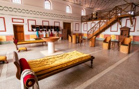 Römischer Raum mit Liegen, Stühlen und Treppe.