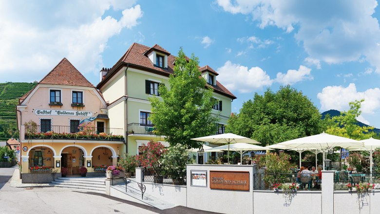 Gasthof 'Goldenes Schiff' mit Terrasse und Sonnenschirmen.