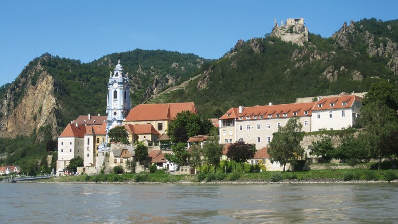 Stift Dürnstein an der Donau mit Burgruine im Hintergrund.