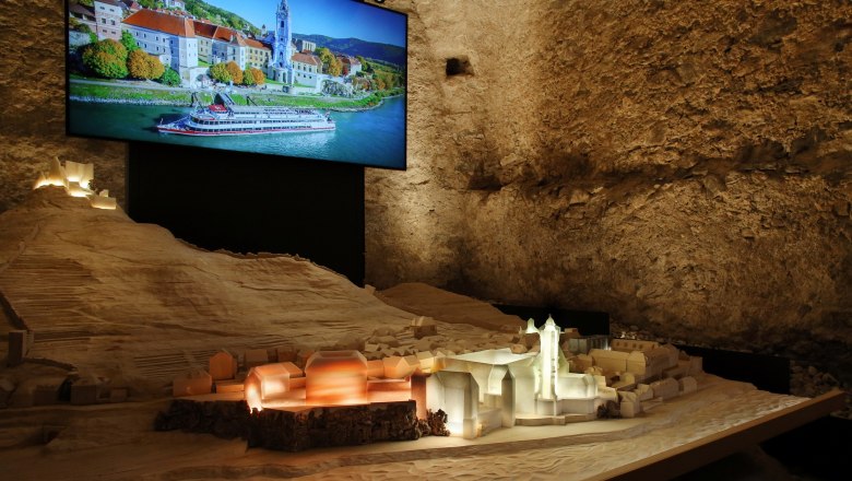Modell von Dürnstein mit beleuchtetem Stift und Foto im Hintergrund.