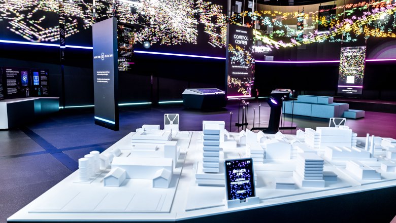 Innenansicht des Hauses der Digitalisierung mit digitalen Displays und einem Architekturmodell.